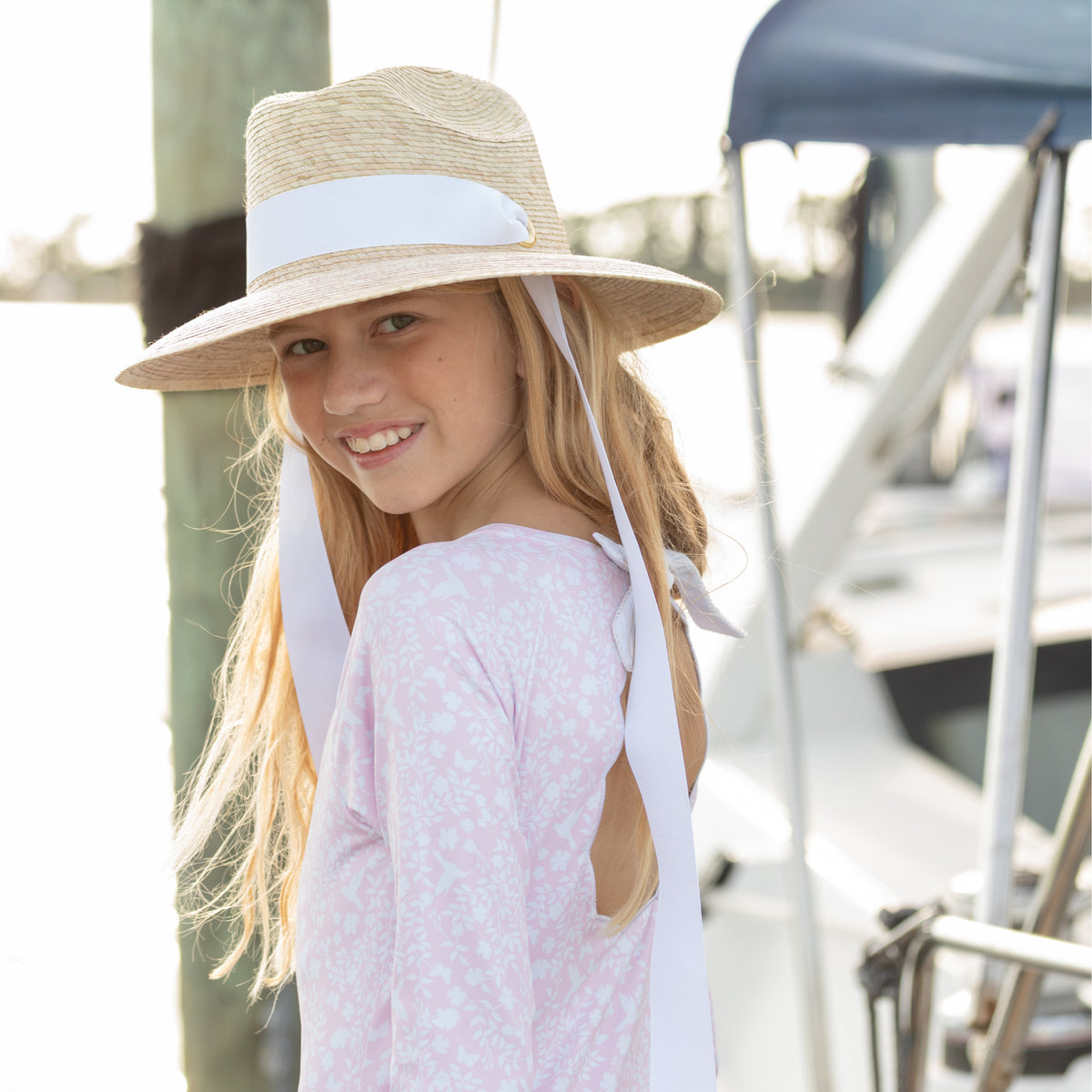 Girls’ long sleeve rashguard one piece swimsuit in Seaside Seersucker with UPF 50+ and scalloped open back, perfect for summer or beach vacations by Henry Duvall.