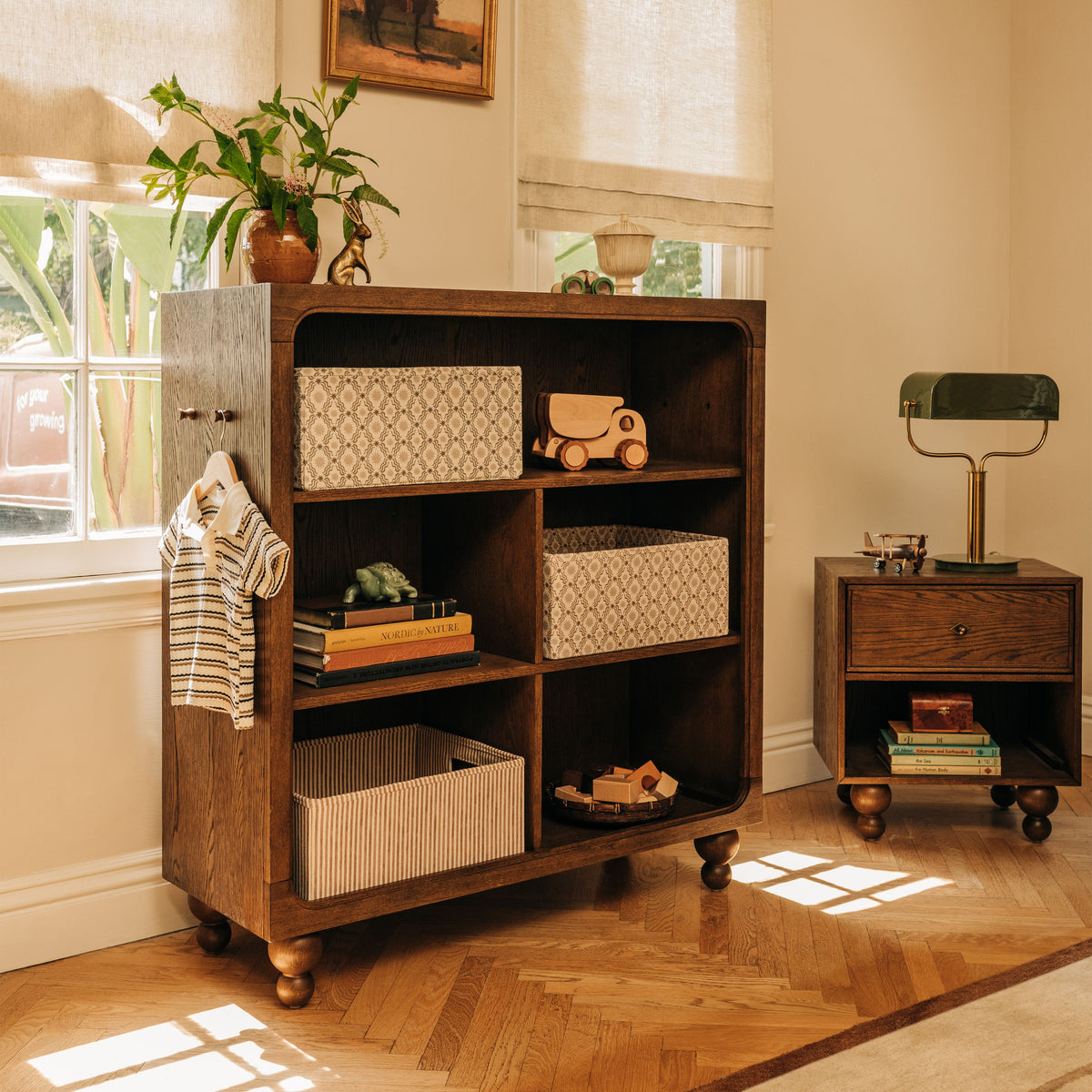 Front view of Astre Assembled Nightstand by Nate Berkus in Toffee showcasing drawers beside a lamp in a sunlit room