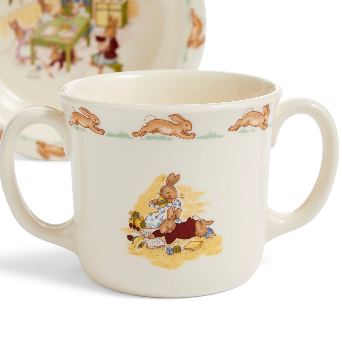 Close-up view of Bunnykins Baby Bowl and 2 Handle Mug set showcasing rabbit illustrations with bowl behind on white background