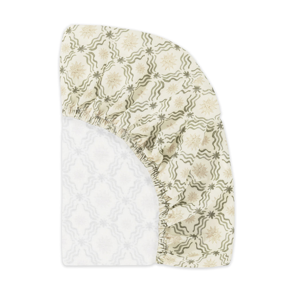 Folded Juniper Star bassinet sheet showing its cream and green patterned fabric on a white background