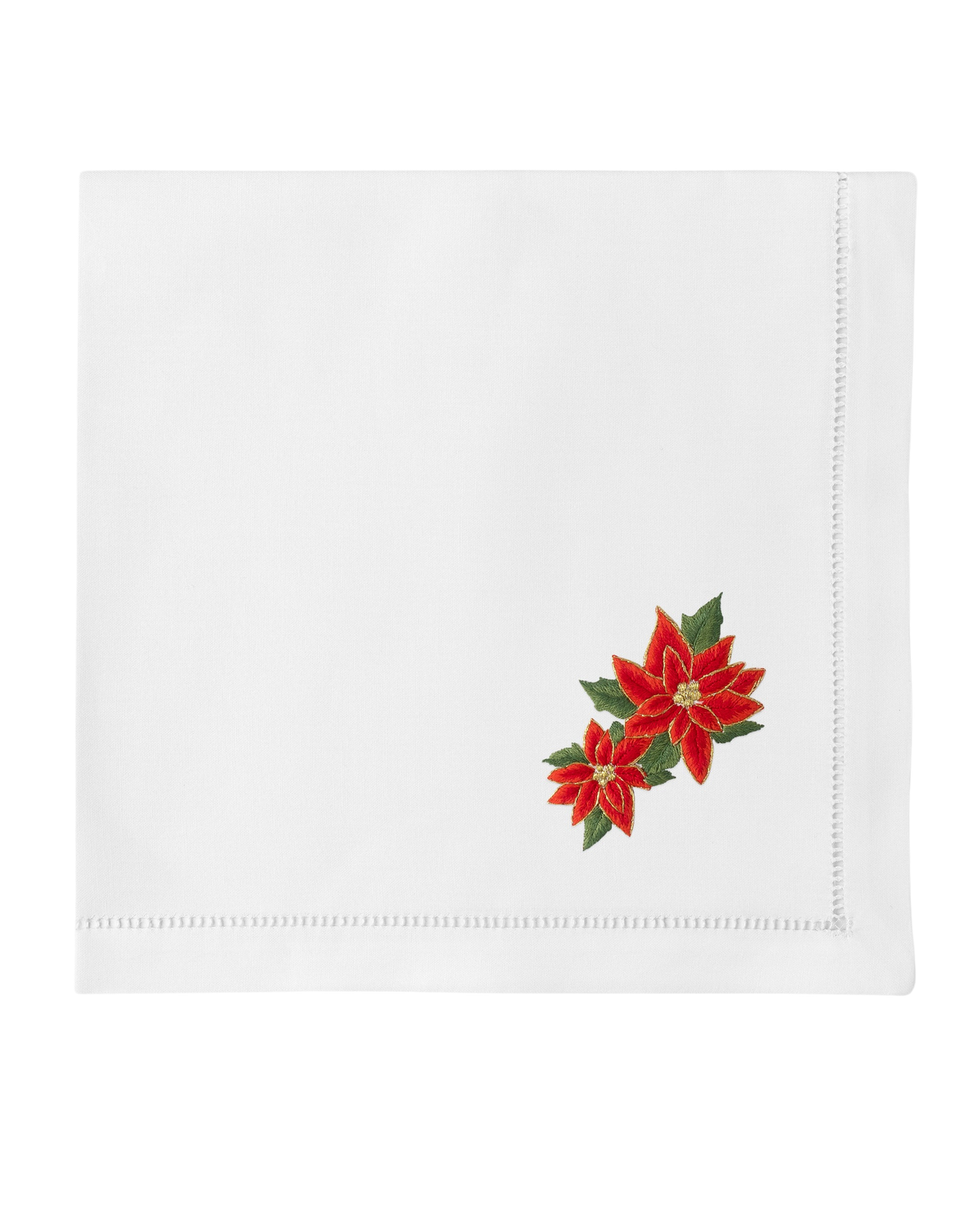 Top-down view of white cotton napkin with hand-embroidered red poinsettias in lower-right corner and hemstitched edges