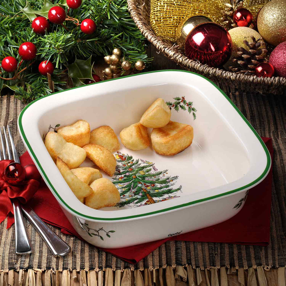 Angled top view of 10-inch square baker showing Spode Christmas Tree design and green rim on a festive table setting