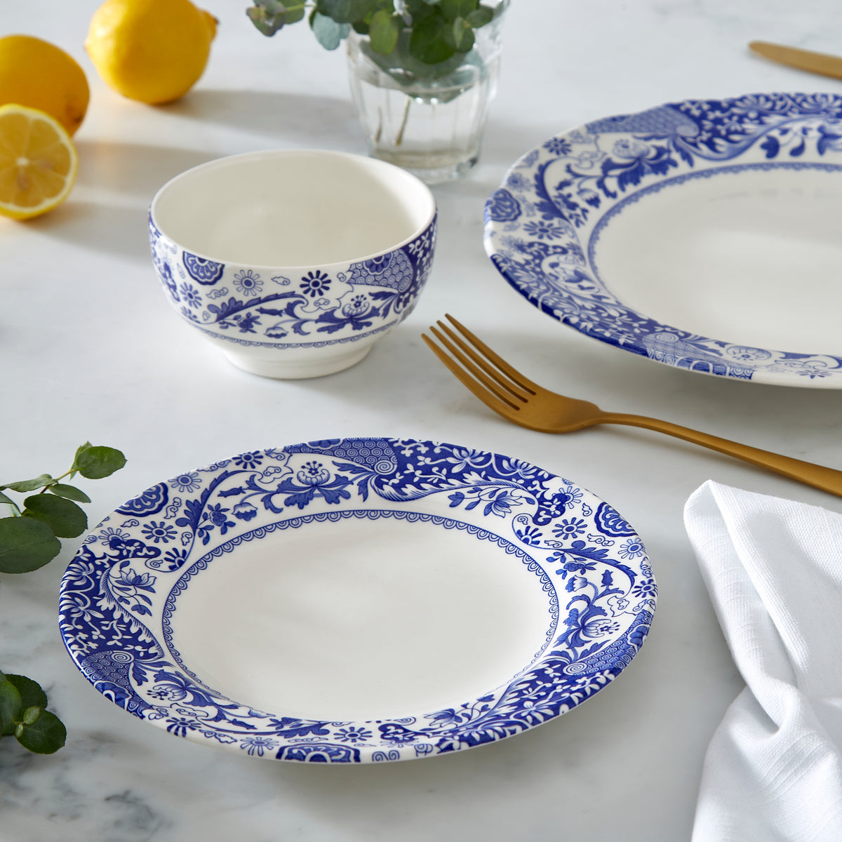 Close-up of Brocato round charger showcasing blue floral pattern with table setting background