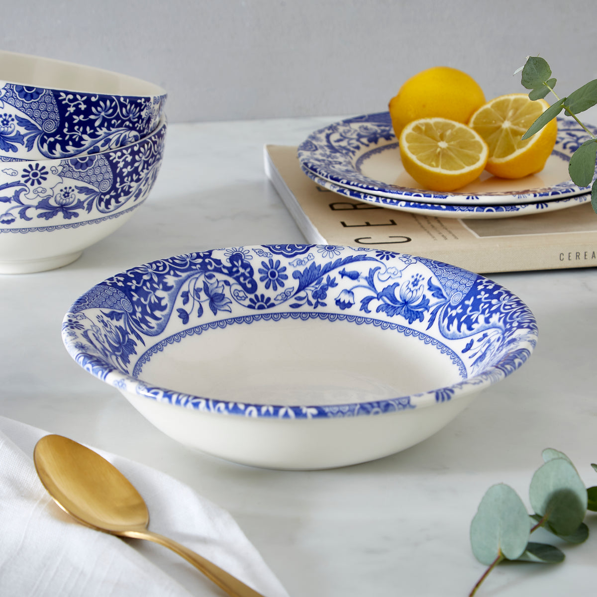 Close-up of Brocato Cereal Bowls, Set of 4 showcasing white porcelain with scroll and floral design on a table