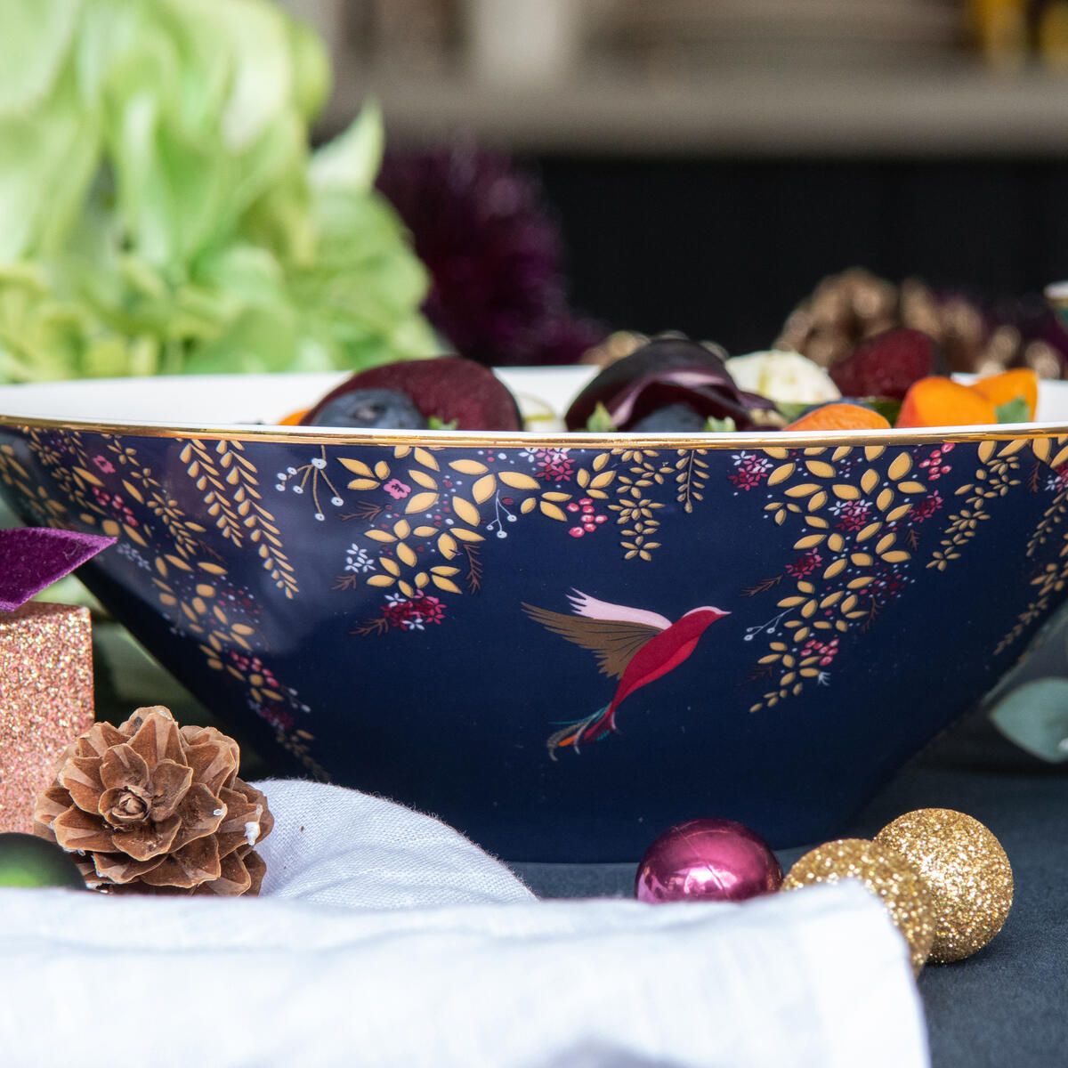 Close-up of Sara Miller Chelsea Collection salad bowl showcasing navy floral pattern, gold rim, and hummingbird design