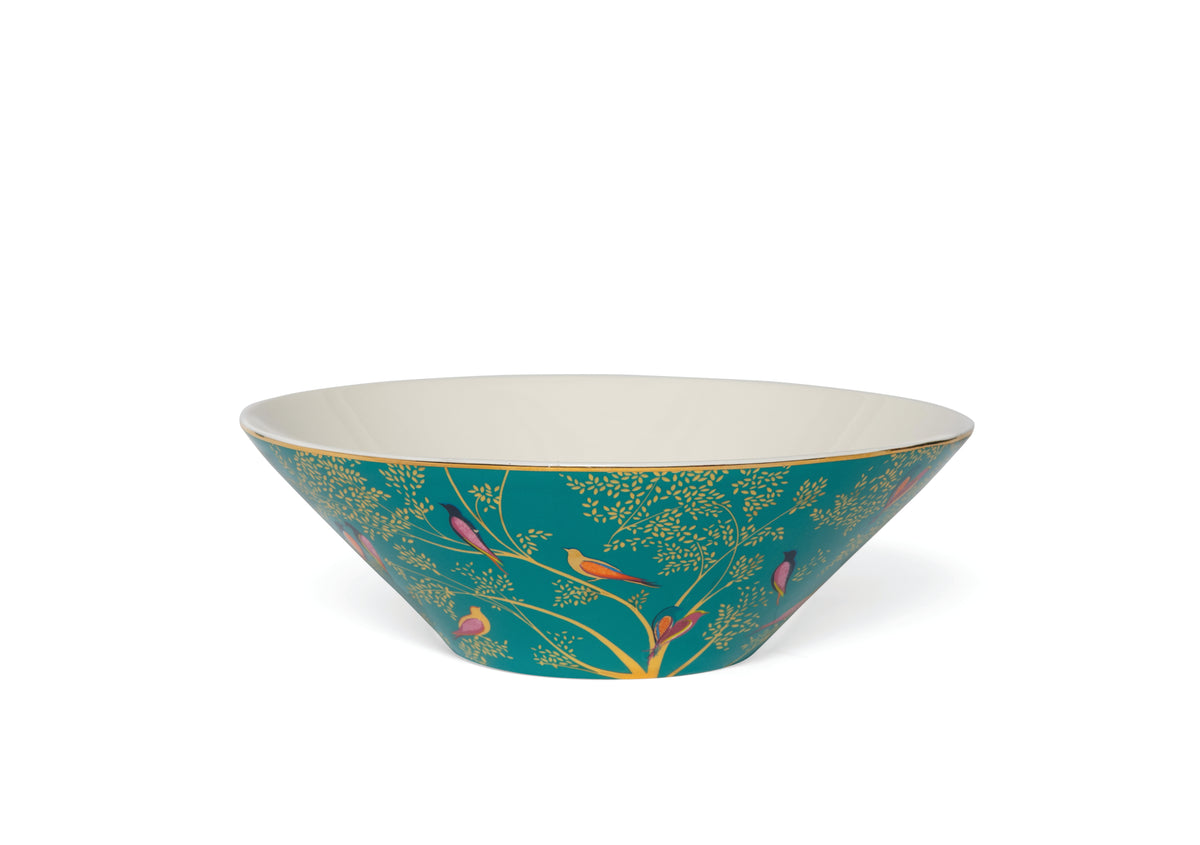 Angled view of Sara Miller Chelsea Collection salad bowl with teal exterior, pink and gold birds, and 22 karat gold rim