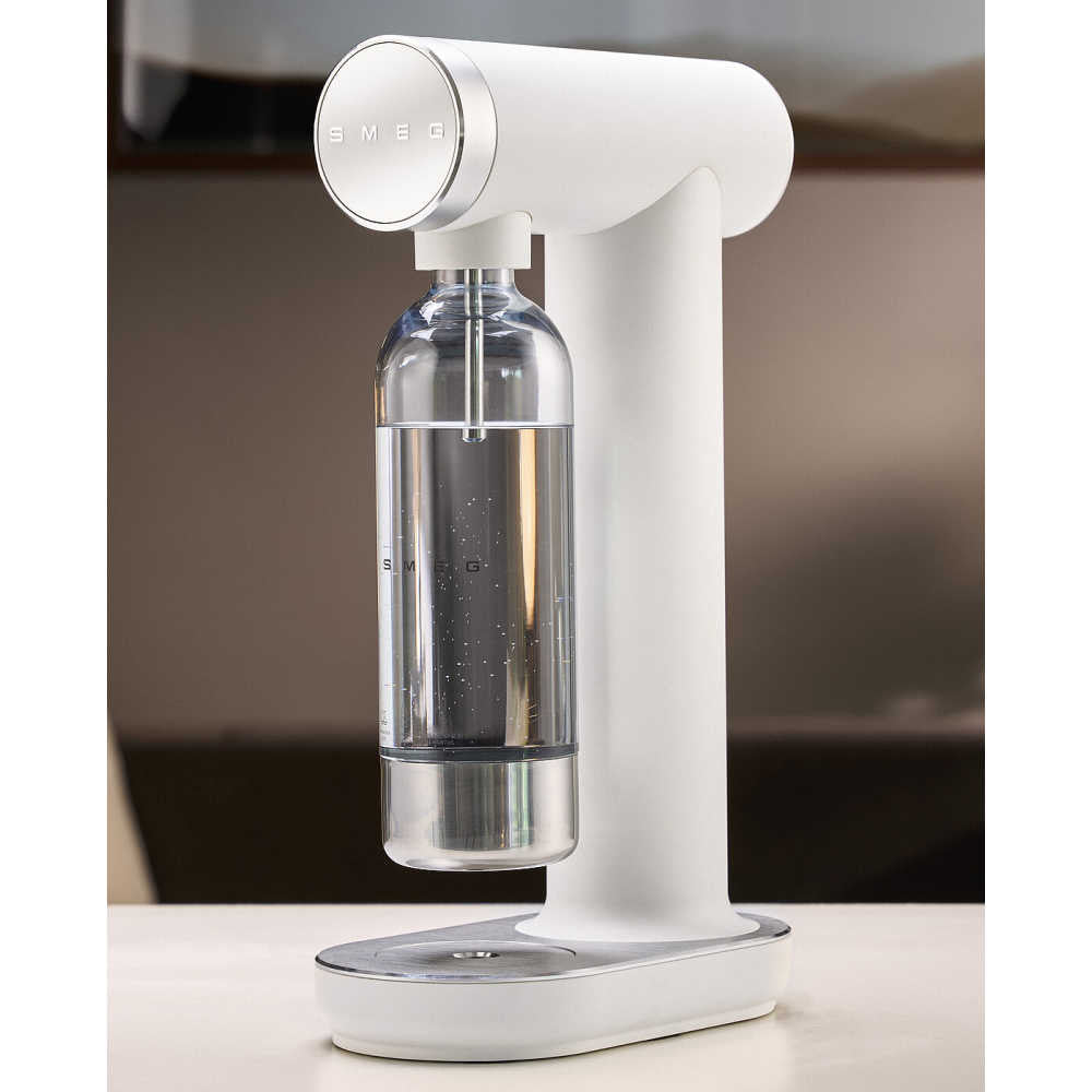 Three-quarter view of SMEG Sparkling Water Maker in matte white with attached clear Tritan bottle and retro rounded silhouette