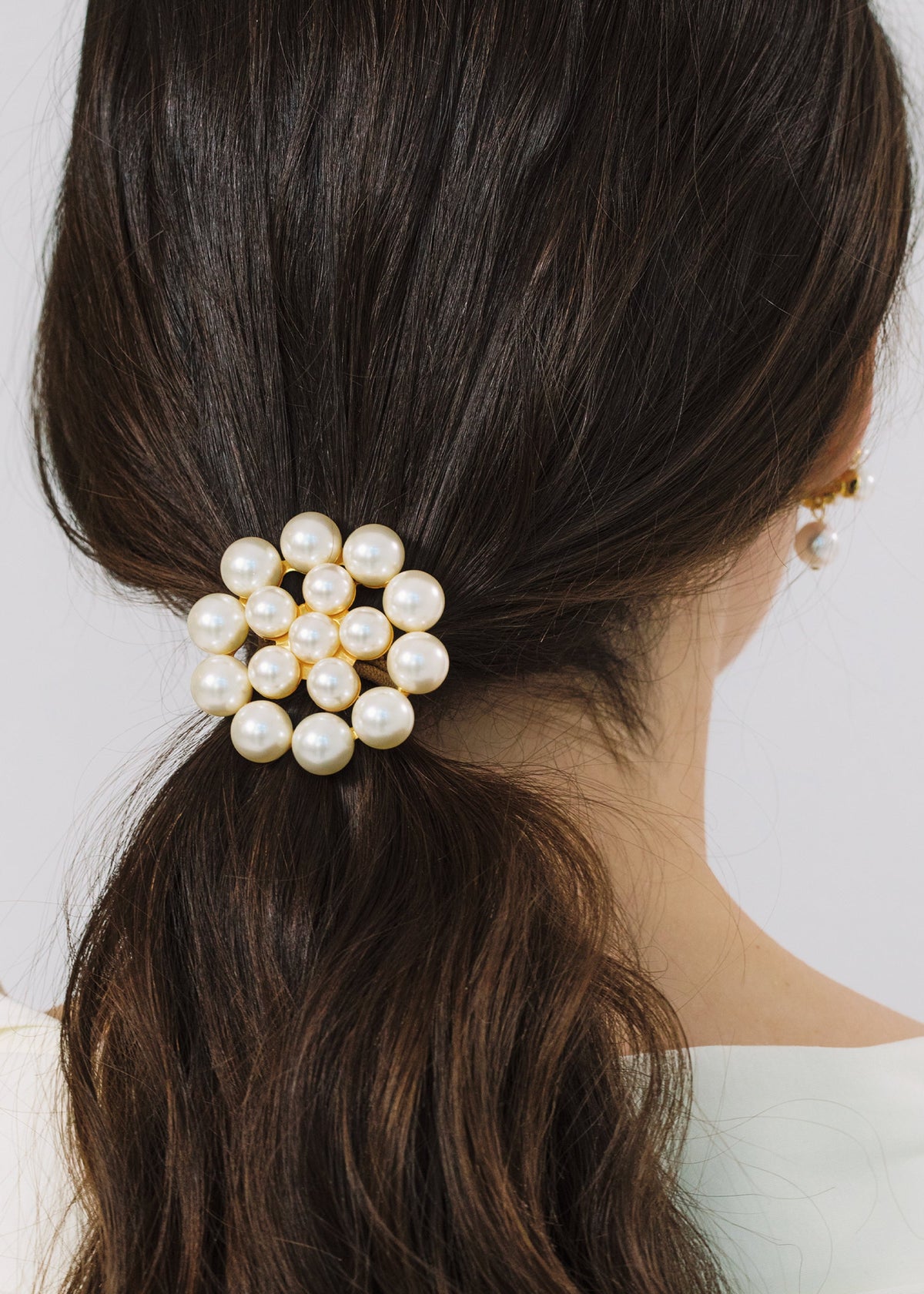 Back view of Paige Ponywrap in Pearl with clustered Czech crystal pearls in an 18 karat gold plated setting on dark hair