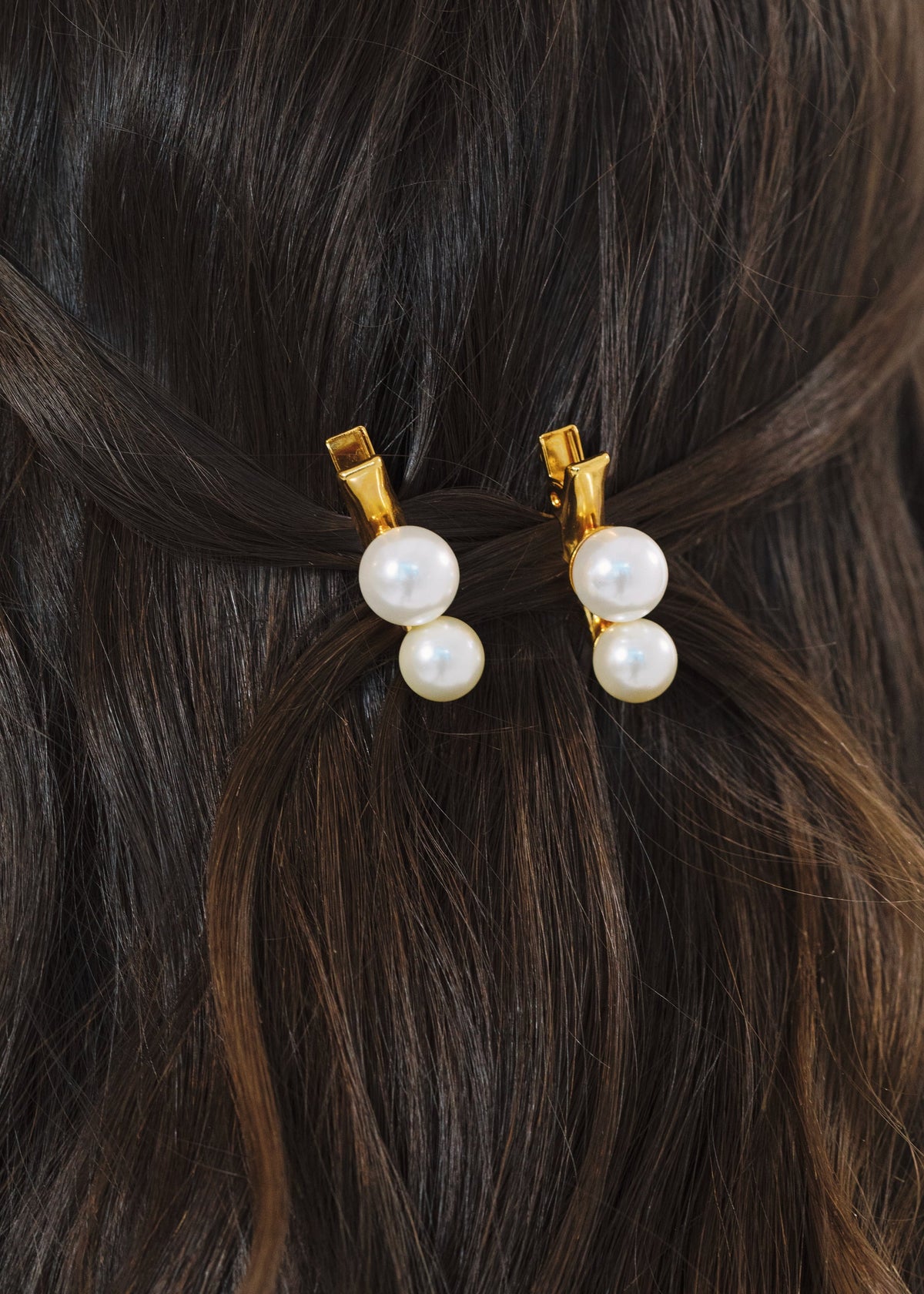 Close-up of Gretel Hair Clips in Pearl showcasing luminescent Czech crystal pearls and gold plated clips in dark hair