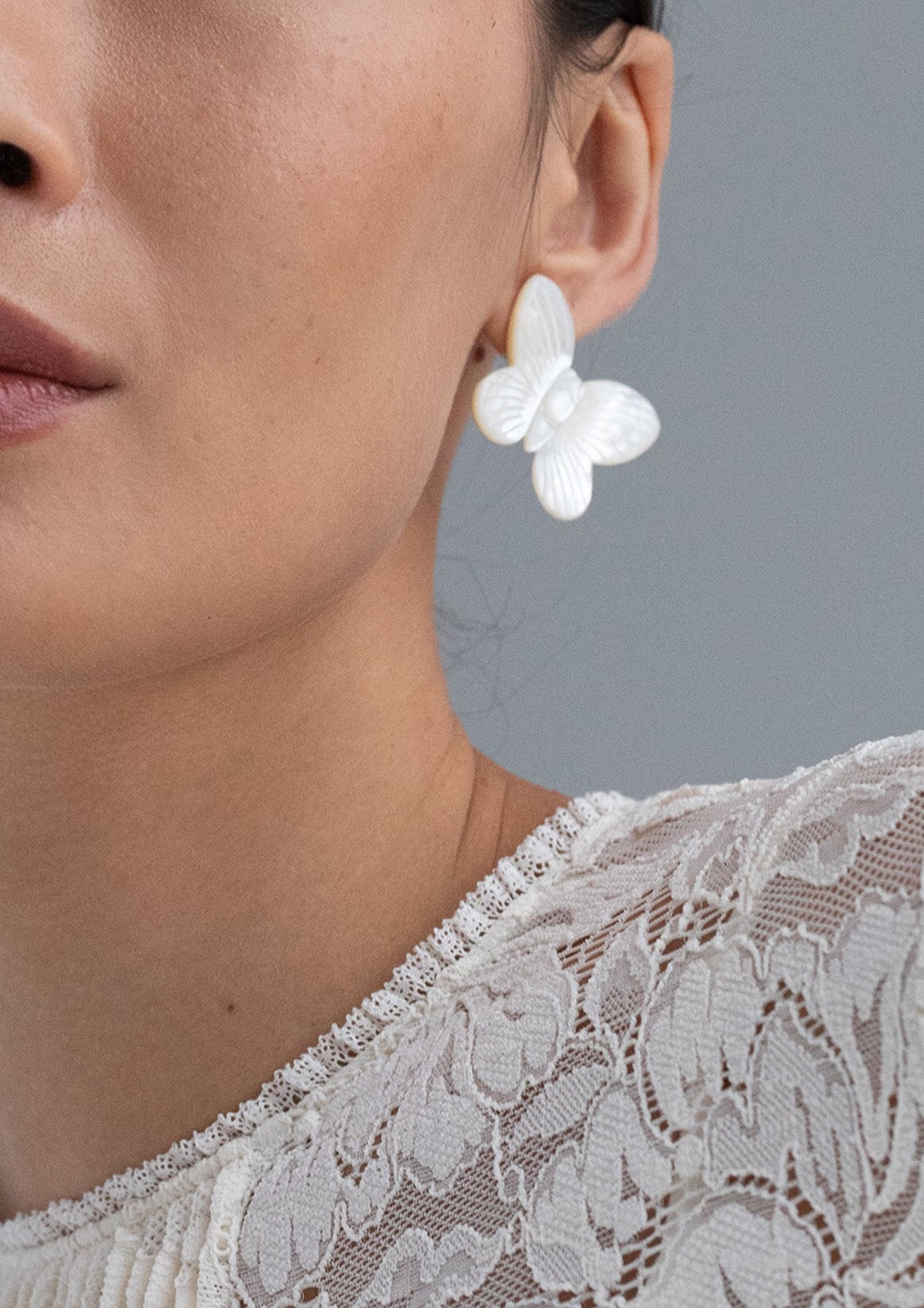 Close-up side view of Bree Earrings in Mother of Pearl showcasing a butterfly earring on the ear with lace top