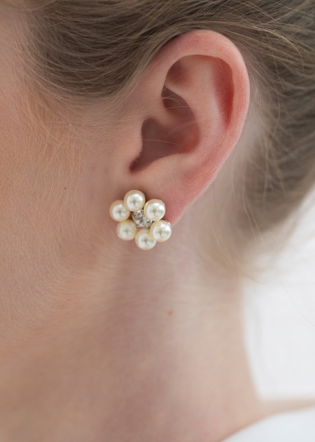 Close-up of Zaya Studs in Crystal showcasing a pearl and crystal flower design on an ear