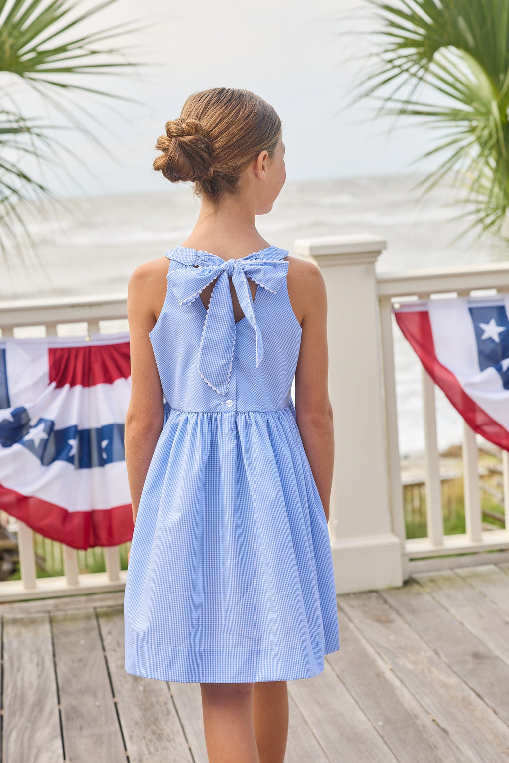 Little English traditional children's clothing.  Royal blue mini gingham sleeveless dress with white ricrac trim and bow tie in back for little girls