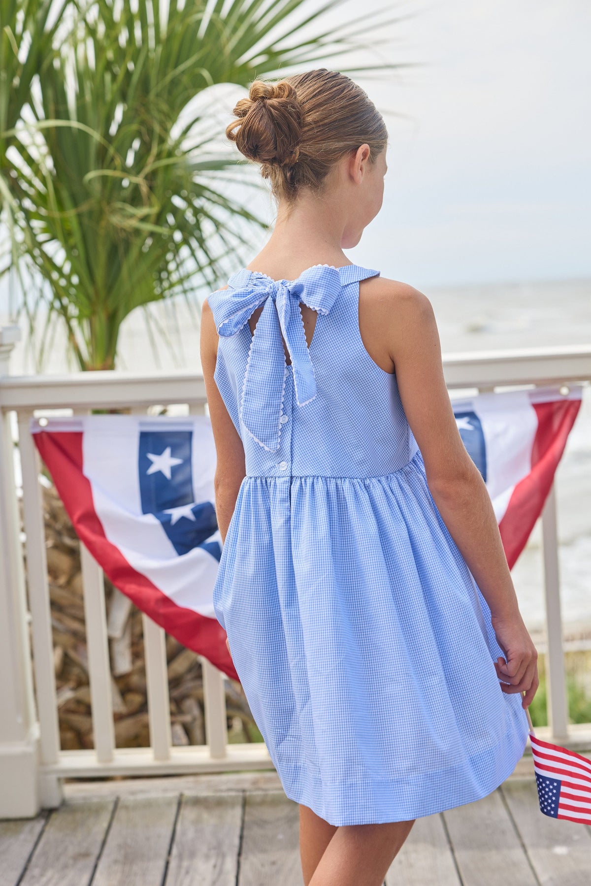 Little English traditional children's clothing.  Royal blue mini gingham sleeveless dress with white ricrac trim and bow tie in back for little girls