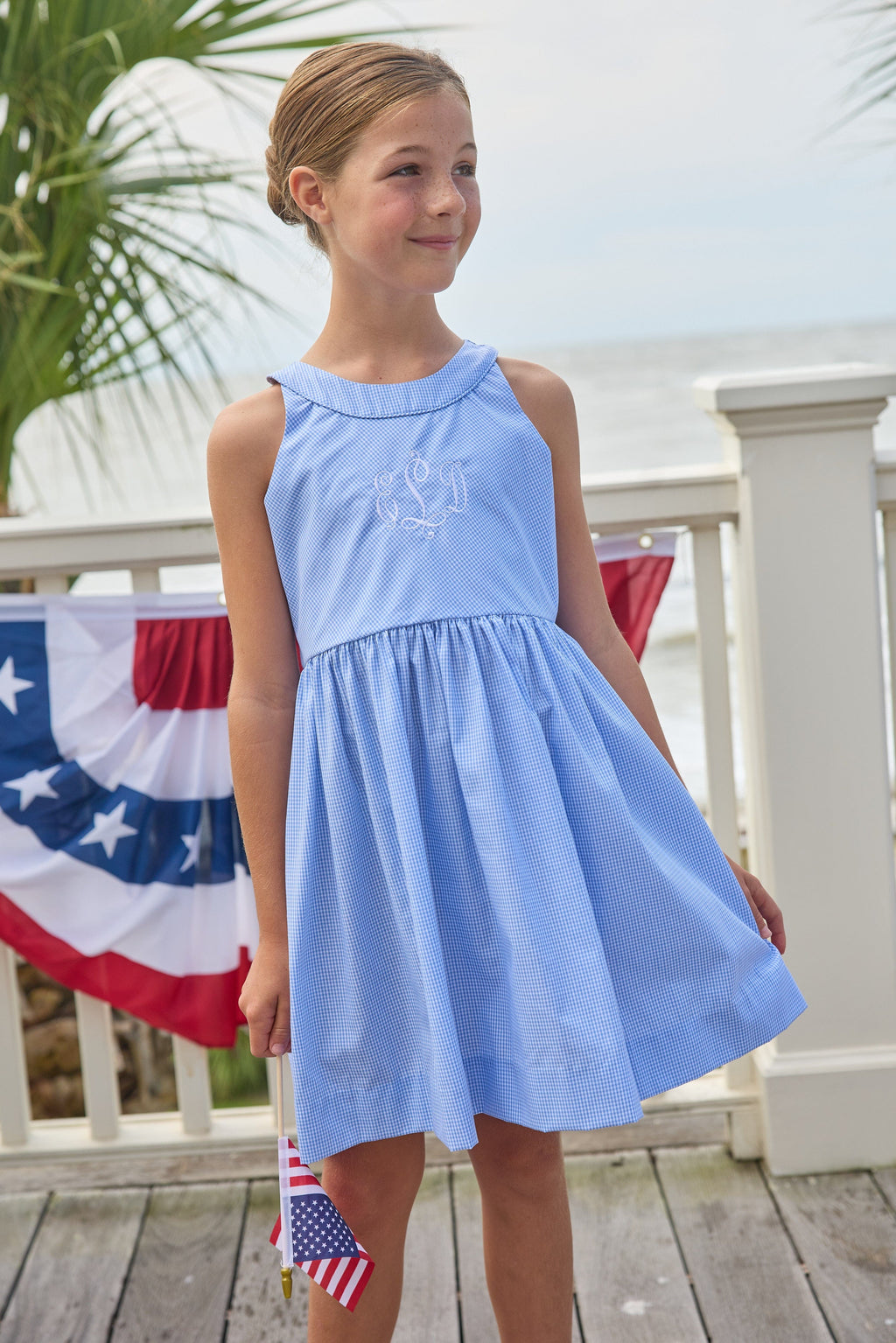Little English traditional children's clothing.  Royal blue mini gingham sleeveless dress with white ricrac trim and bow tie in back for little girls