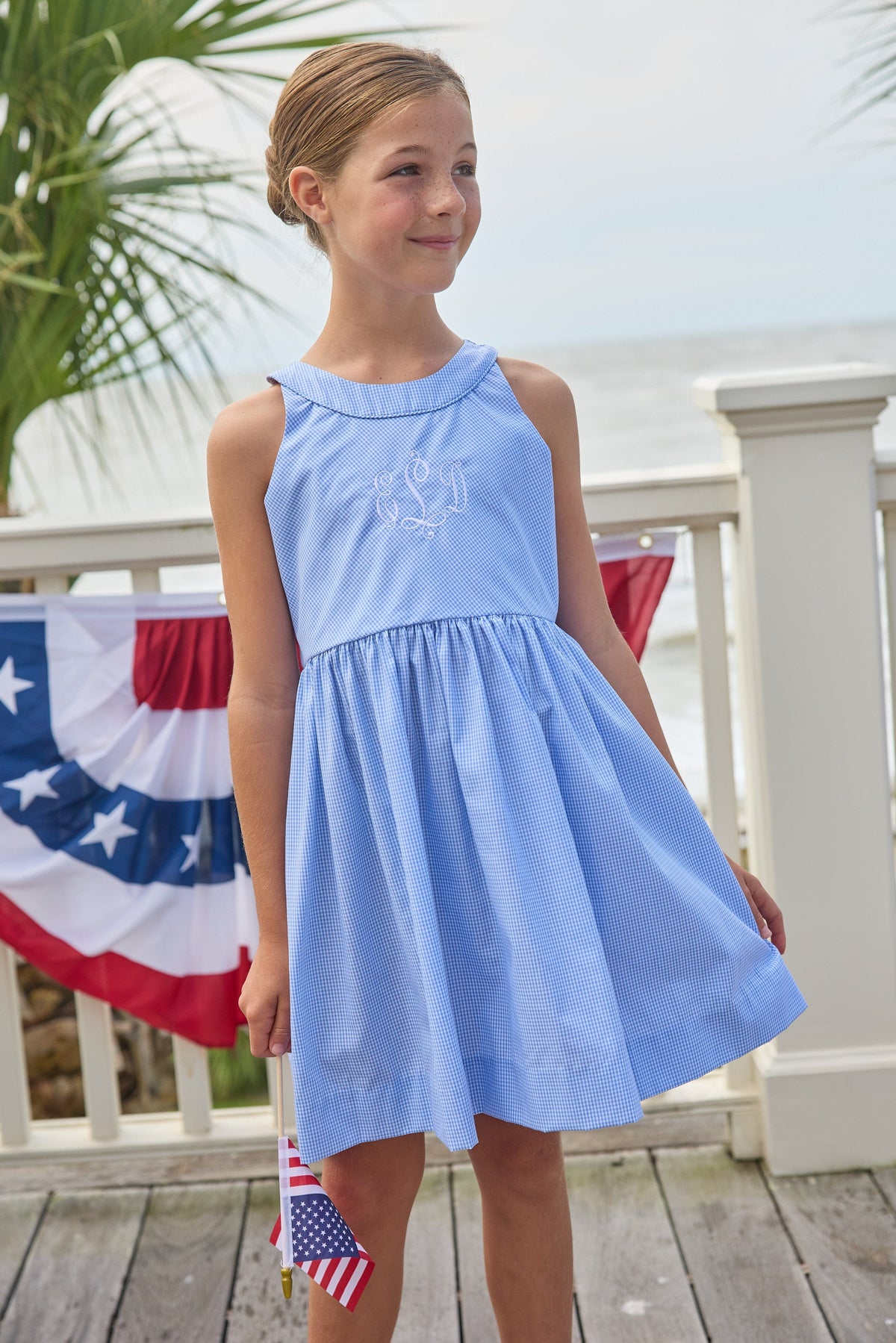 Little English traditional children's clothing.  Royal blue mini gingham sleeveless dress with white ricrac trim and bow tie in back for little girls