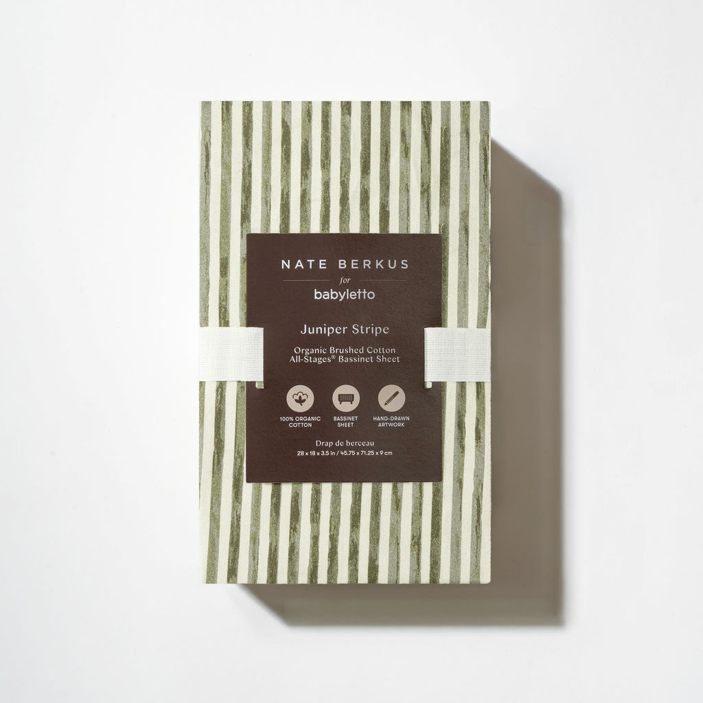 Front view of All-Stages Bassinet Sheet in Juniper Stripe showcasing green and white vertical stripes in white packaging