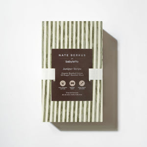Front view of All-Stages Bassinet Sheet in Juniper Stripe showcasing green and white vertical stripes in white packaging