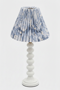 Inner Child table lamp with white stacked base and hand-marbled pleated shade with ocean wave blue patterns