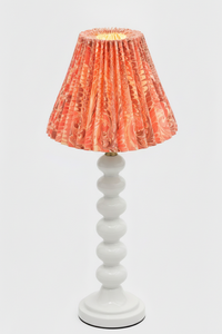 Table lamp with white stacked base and lit hand-marbled pleated lampshade