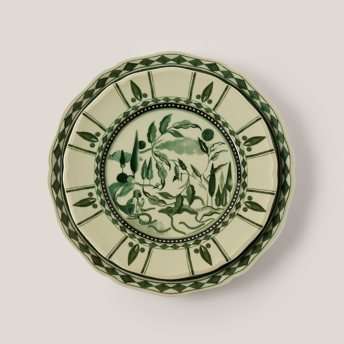 Top view of Reverie des Pins dessert plate in Amande showcasing green gouache illustration and scalloped edge on pale background
