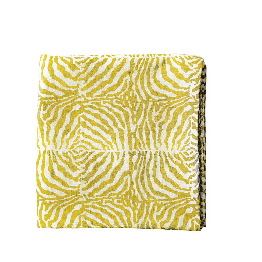 Folded view of Zebra Yellow Tablecloth in Linen showcasing its yellow and white zebra stripe pattern on a black background