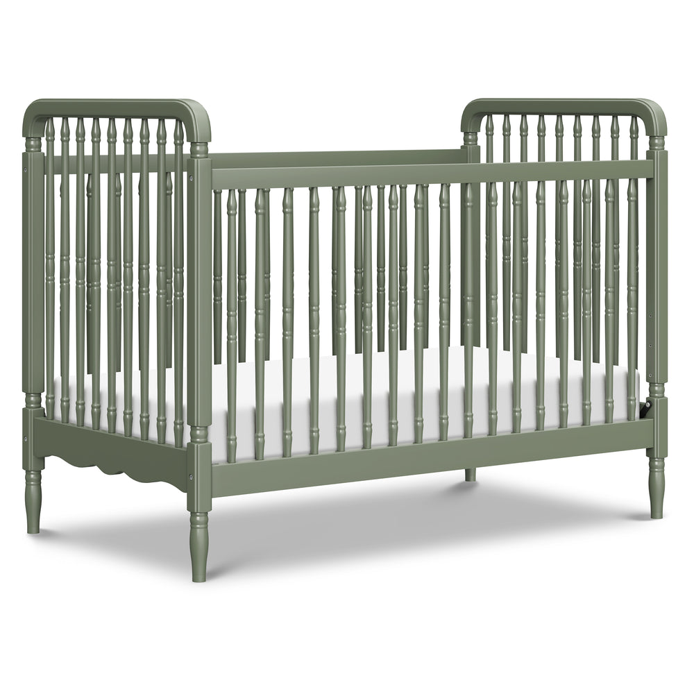 Front three-quarter view of Liberty convertible spindle crib in Juniper showcasing turned spindles on white background