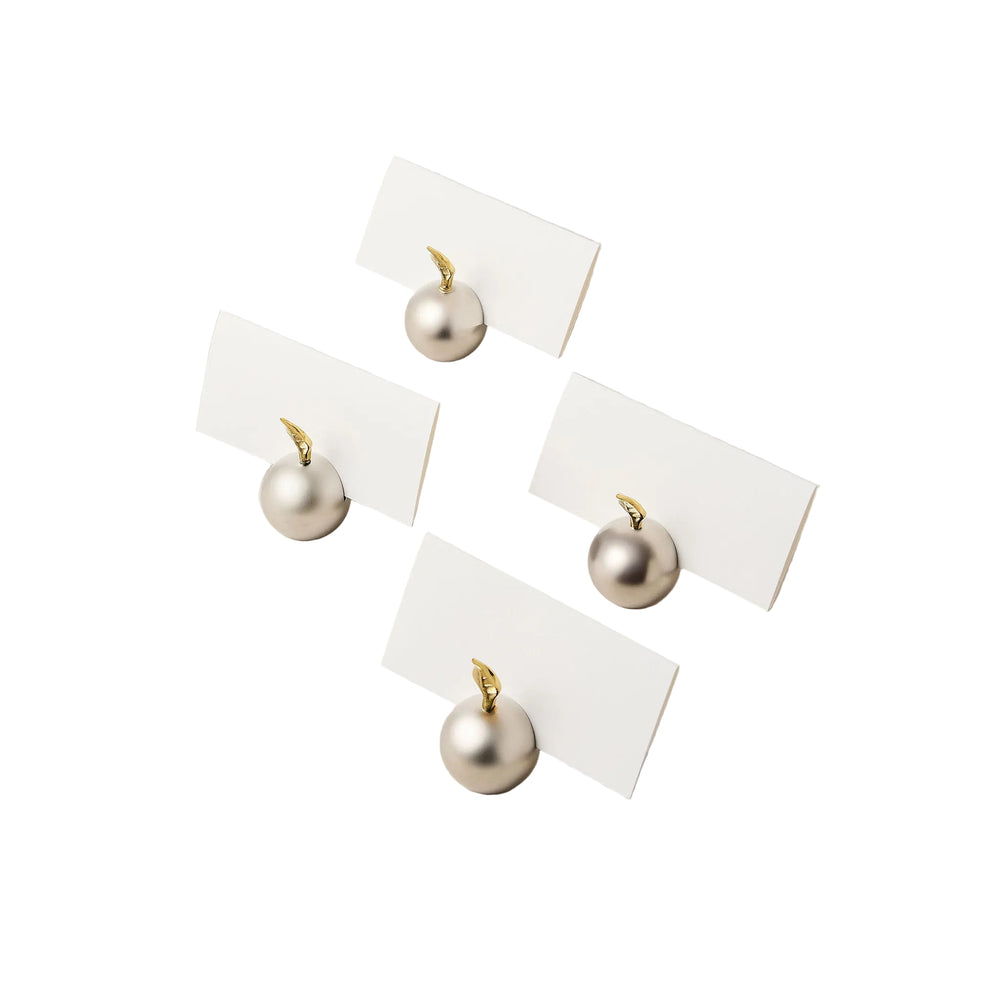 Angled view of Les Arbres placecard holders showcasing hand-cast brass spheres with gold leaf stems holding white placecards