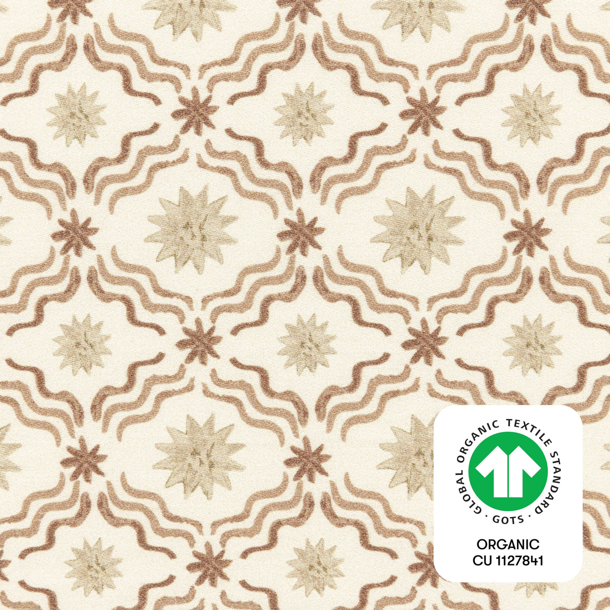 Close-up of All Stages Bassinet Sheet in Autumn Star showing starburst and wavy pattern with GOTS organic textile badge