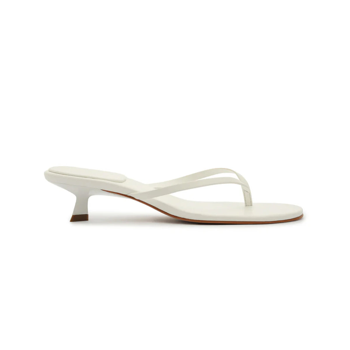 Side view of Carolyn Sandal in white showcasing low kitten heel and thin thong straps on white background