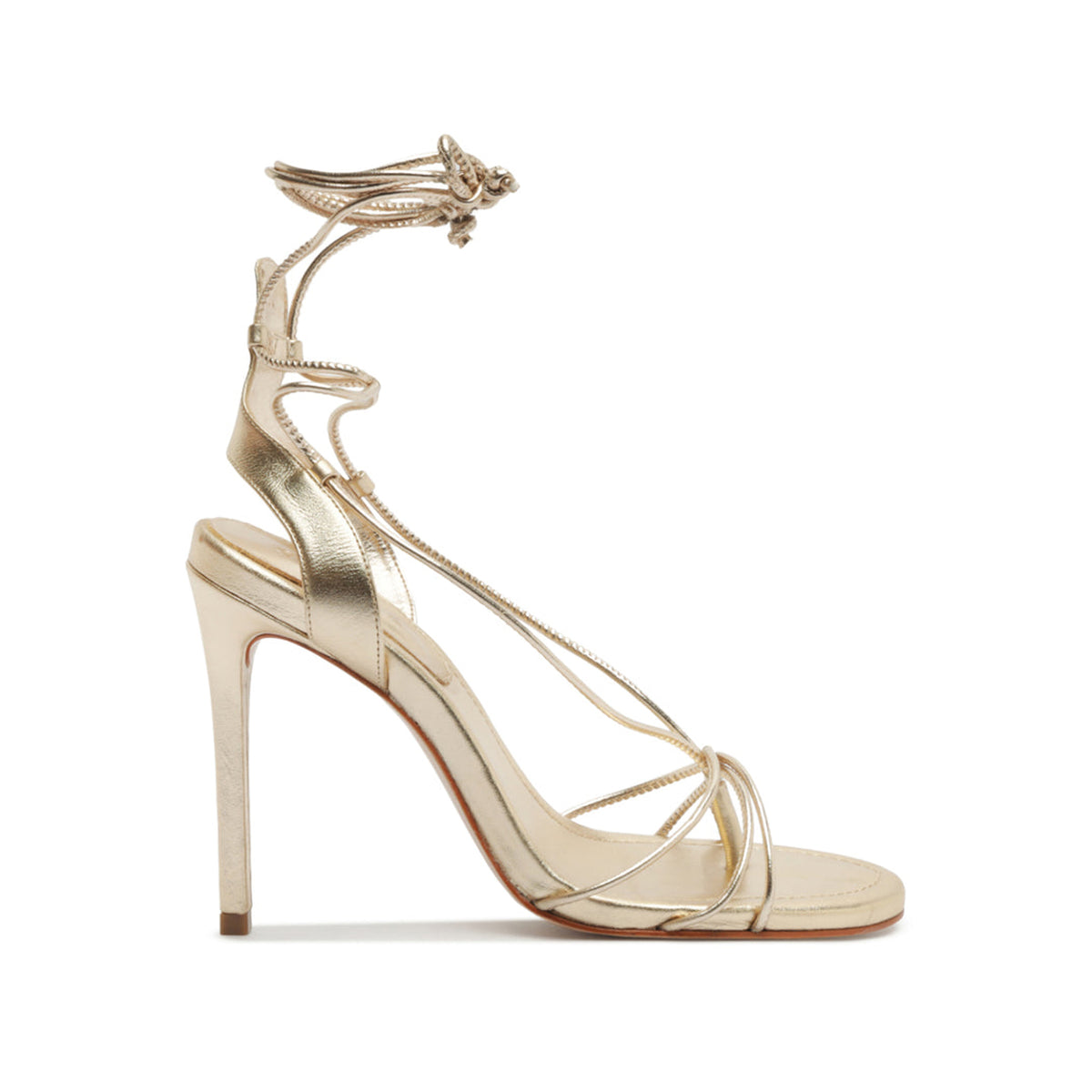 Side view of Demetria metallic sandal in platinum showing wraparound lace-up straps, slim stiletto heel, open toe on white