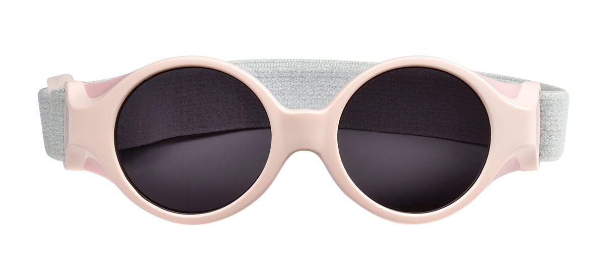 Front view of Glee Infant Sunglasses in Chalk Pink showcasing side shells and elasticated headband on white background