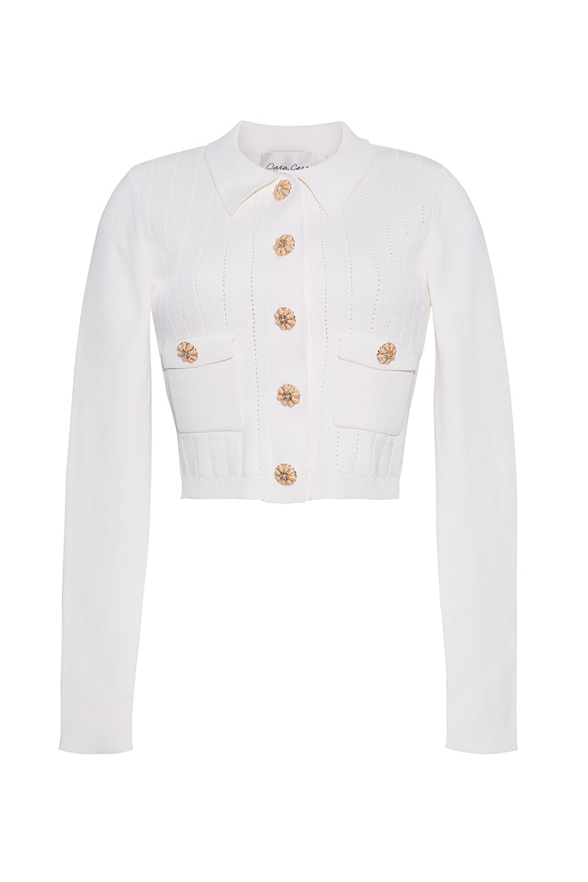 Front view of the white Patty Cardigan with raffia buttons, pointelle stitch, long sleeves, and waist pockets on white
