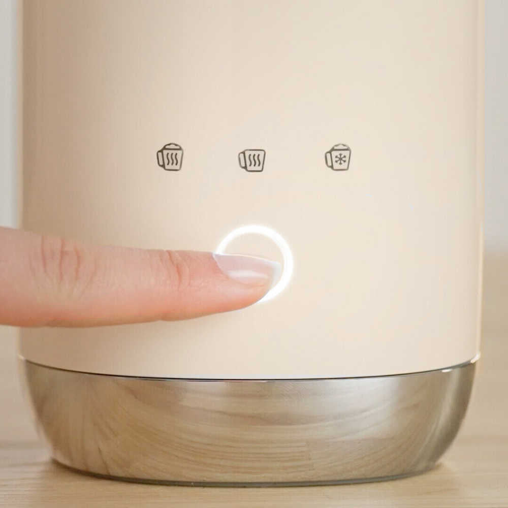 Close-up of SMEG Mini Milk Frother front showing illuminated power button and function icons on cream body with stainless base