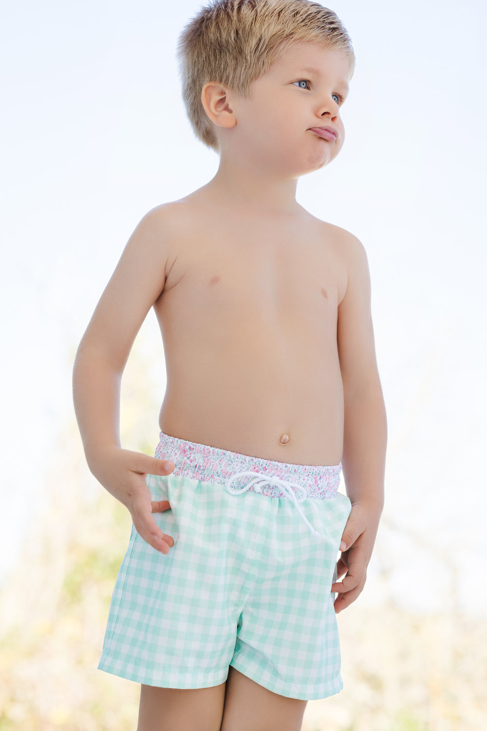 Front view of Pink Ditsy Floral trunks on child showing mint gingham shorts with pink floral elastic waistband and drawstring