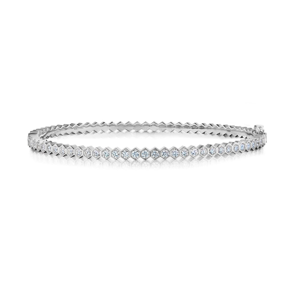 The Hexagon Bezel Set Diamond Bangle in white gold features round, sparkling diamonds set in hexagonal bezels, showcased on a white background.