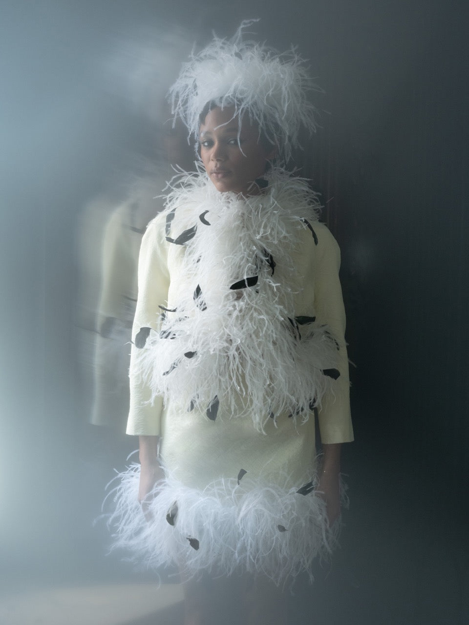 Front view of Emily Jacket showcasing white feather trim with black feather accents on a model against a dark background