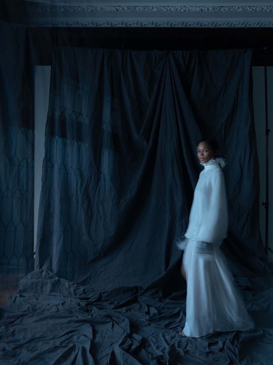 Full length view of Anya Dress showcasing its flowing silhouette with a dark draped backdrop