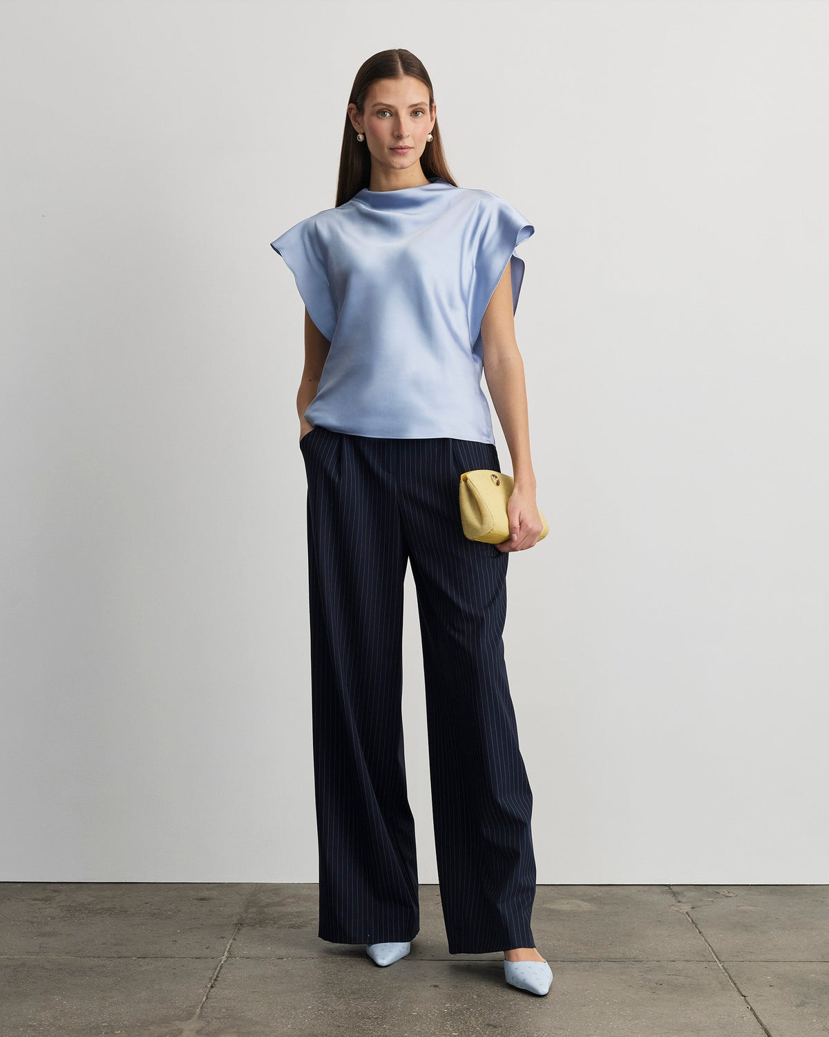 Front view of Adrien Top in powder blue on model showcasing draped neckline and short flutter sleeves, light gray background