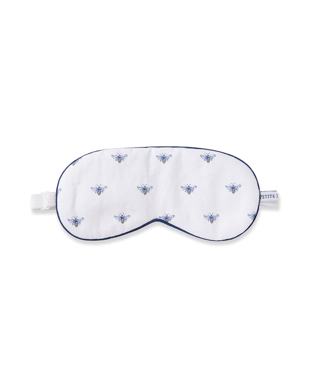 The Adults Twill Sleep Mask in Buzzing Bees by Petite Plume showcases a charming blue bee print with a blue trim, adjustable white strap, and side tag.