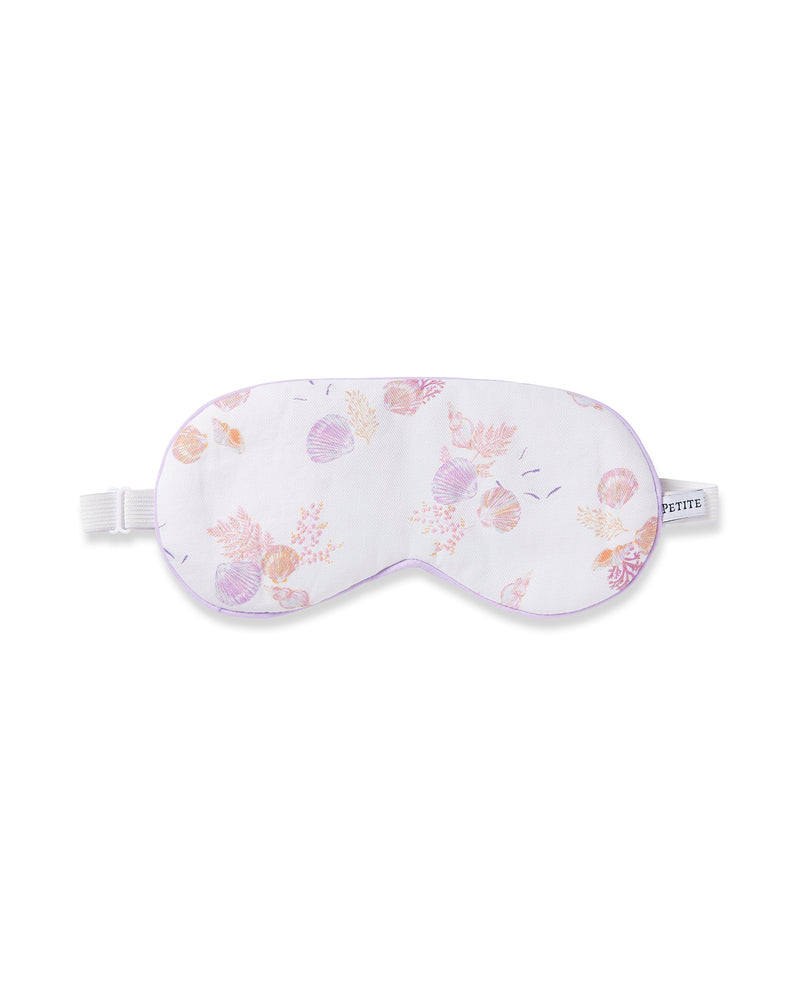 The Petite Plume Adults Twill Sleep Mask in Seashell Splendor features a white base with pink and purple seashell patterns, a matching eye mask, a white elastic strap, and refined purple piping. Ideal for monogrammed gifts.