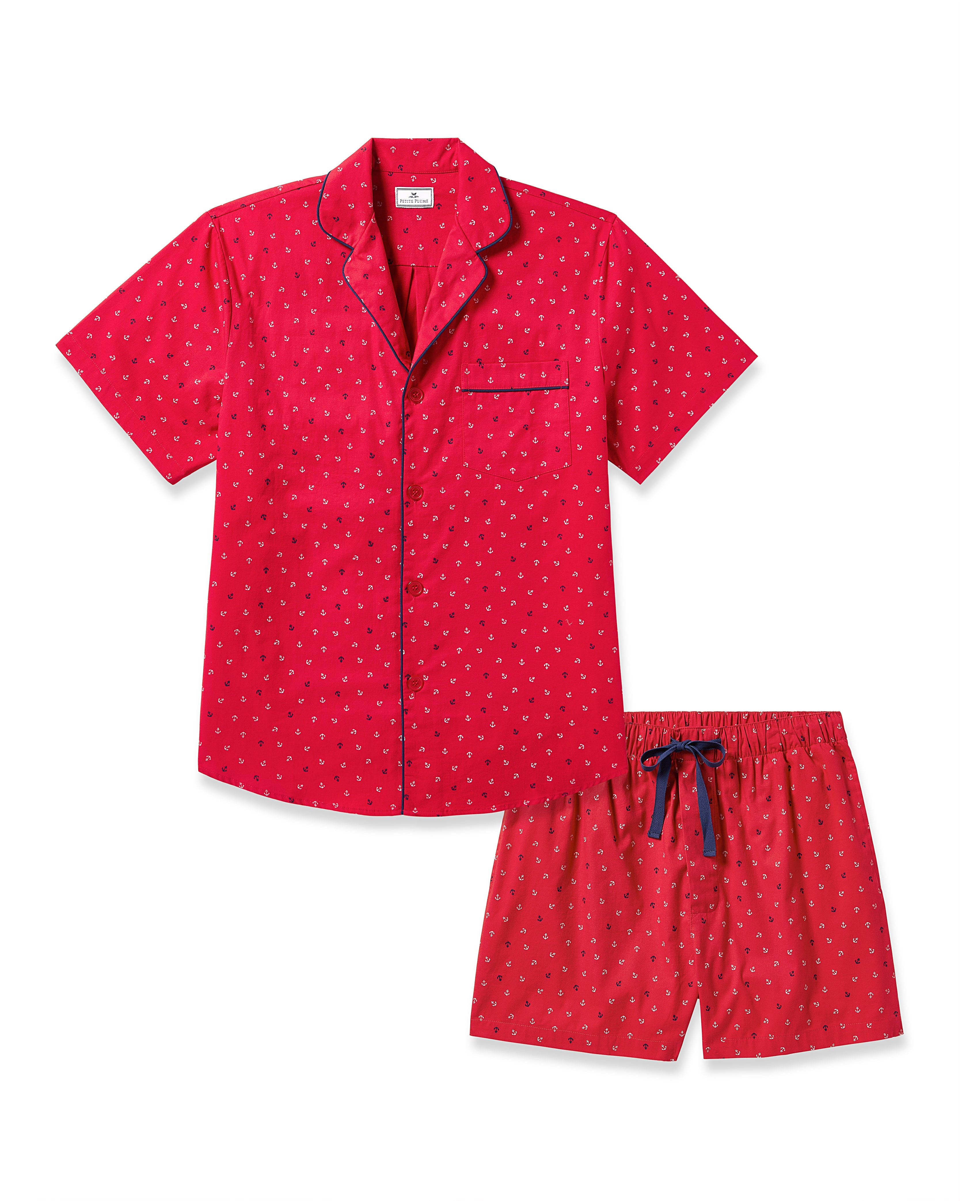 The Mens Twill Short Sleeve Short Set Anchors Away by Petite Plume features a high-quality red cotton pajama set with a short-sleeved button-up top, adorned with the Anchors Away print and black trim. The matching shorts include an elastic waistband and a stylish black tie.