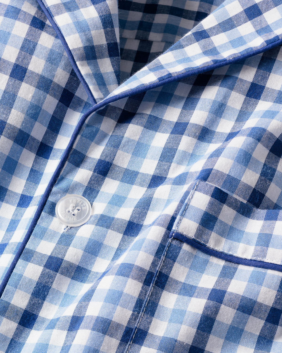 A close-up of the Mens Twill Pajama Short Set in Royal Blue Gingham by Petite Plume, showcasing a buttoned section and pocket with visible stitching, highlights the classic design of luxury cotton sleepwear.