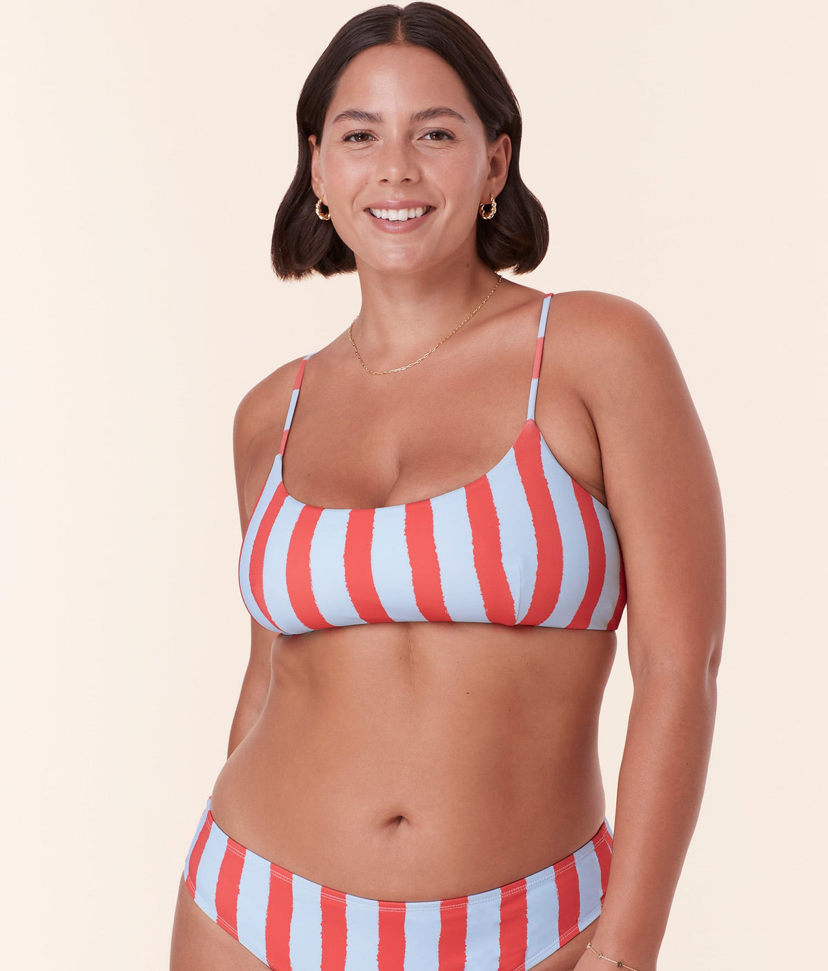 Model confidently wearing Andie Swim's Fiji Bikini Top in Candy Stripe, showcasing the scoop neckline and soft, supportive fit.