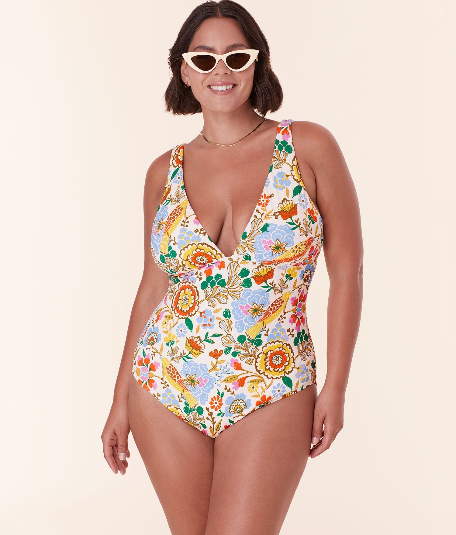 Model wearing Andie Swim’s Augustine One Piece in Bird Floral print with a deep V-neckline and full bottom coverage.