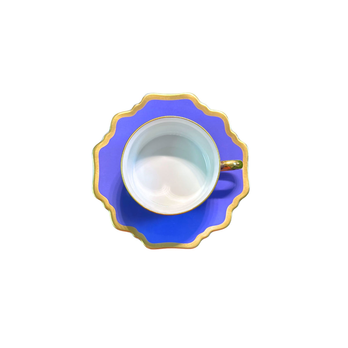 Top view of Anna’s Palette Indigo Blue tea saucer showcasing blue trim and golden rim with white teacup on white background