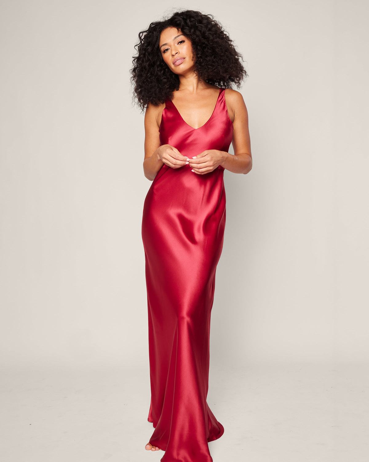 Front view of Women’s Silk Long Slip in Bordeaux showcasing its V neckline and glossy red silk on a model against a plain background