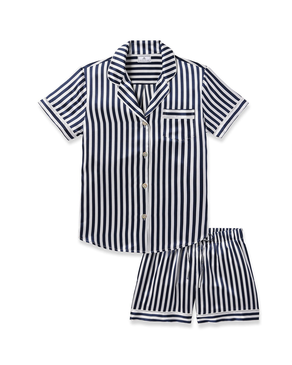 The Petite Plume Womens Silk Short Set in Navy Bengal Stripe is a luxury sleepwear ensemble featuring a short-sleeved, button-up shirt and matching shorts. It boasts navy blue and white vertical stripes plus a single chest pocket for added elegance.