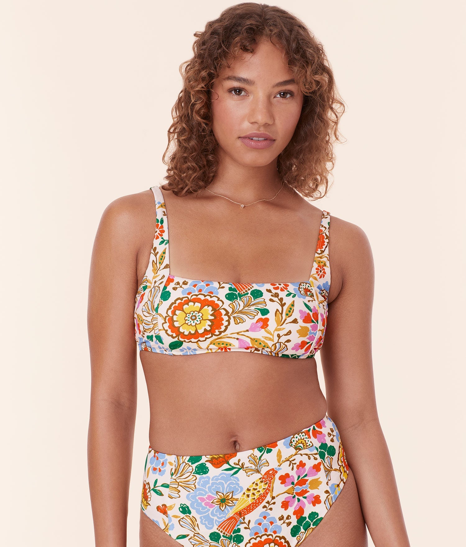 Model confidently wearing Andie Swim's Havana Bikini Top in Bird Floral print with a low square neckline for a timeless, vintage-inspired look.