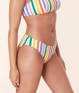 Model wearing Andie Swim's Classic Bikini Bottom in Rainbow Stripe, featuring a low-rise fit and compressive eco nylon fabric for a sculpting look.