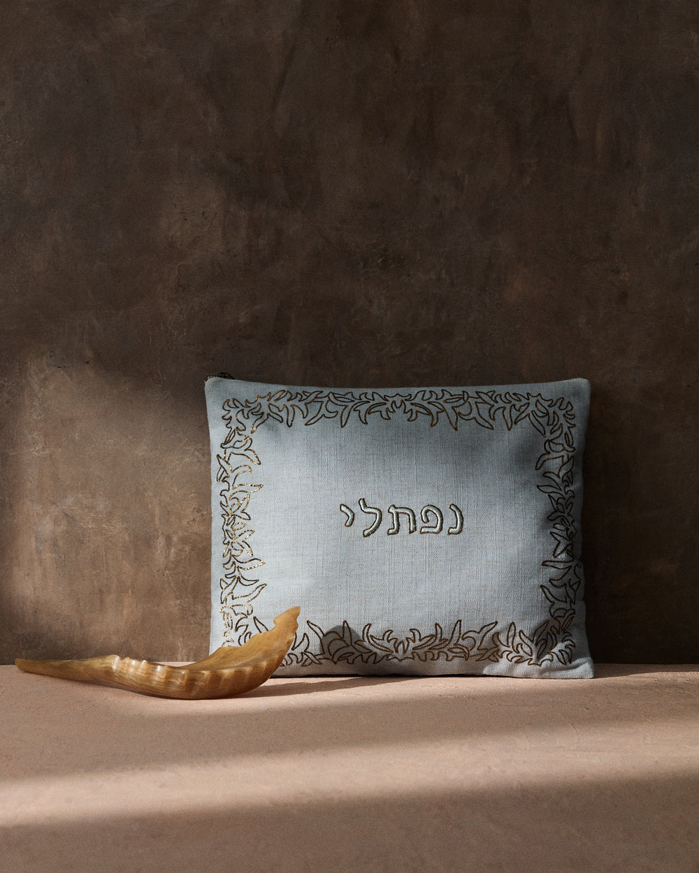 Front view of Naftali tallit and tefillin bag with embroidered Hebrew נפתלי and metallic leaf border on sage linen